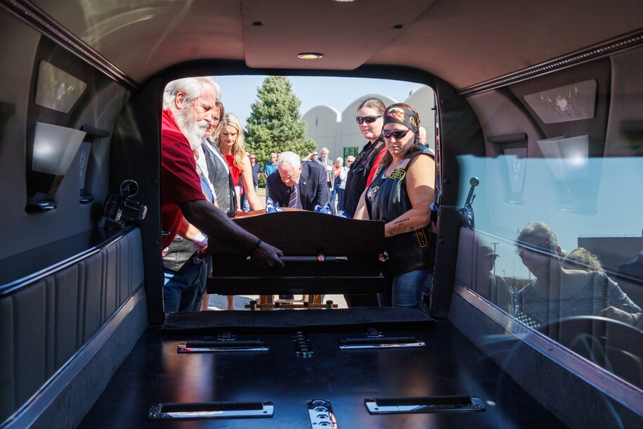 Pallbearers load 